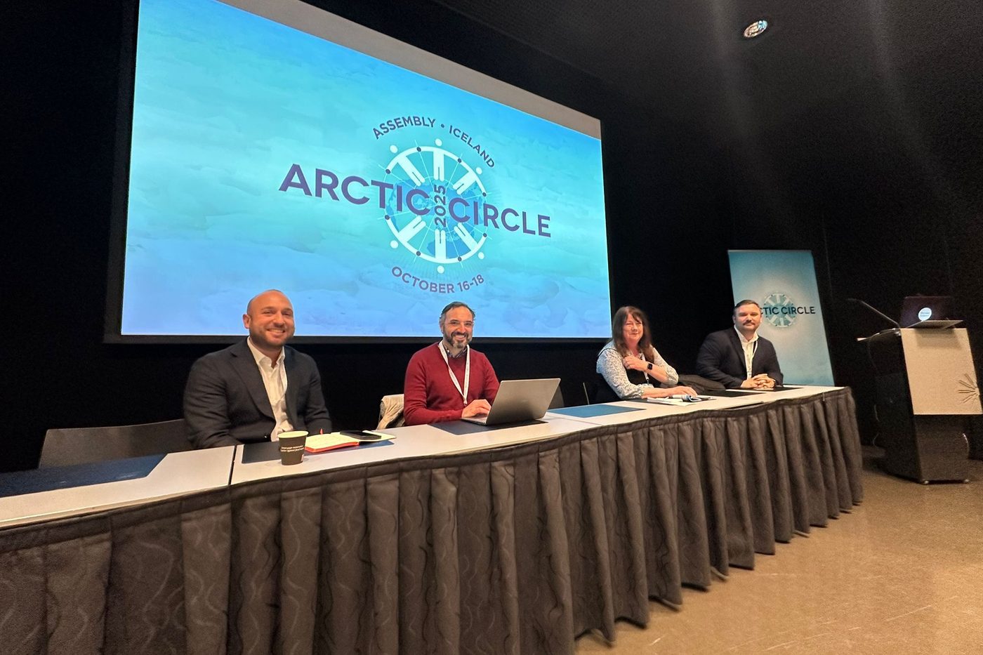 Four panellists seated on stage in front of an Arctic Circle 2025 screen