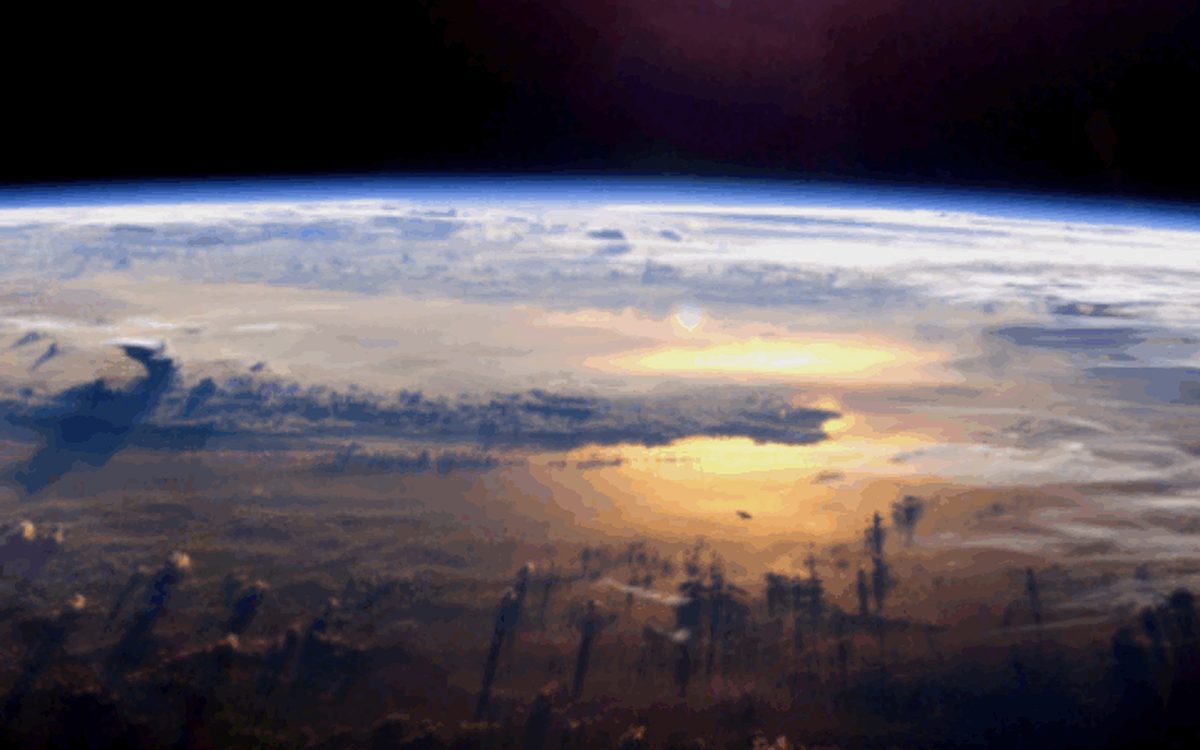 Earth seen from orbit with the sun rising over the horizon